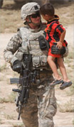 A soldier holds onto a local child near Kirkuk, Iraq