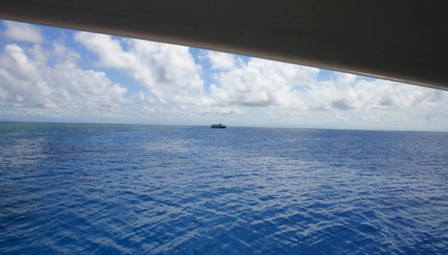 A ship is seen in the distance while diving in the Great Barrier Reef