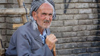 An old man sits on the street in Erbil, Iraq